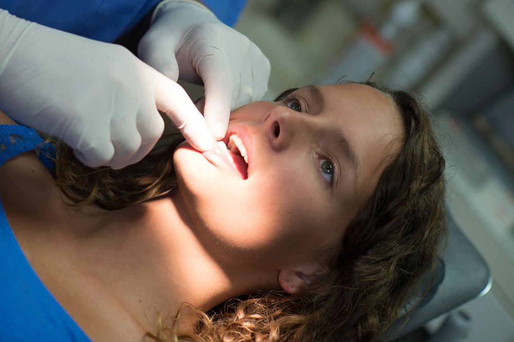 Female patient undergoing an oral cancer screening.
